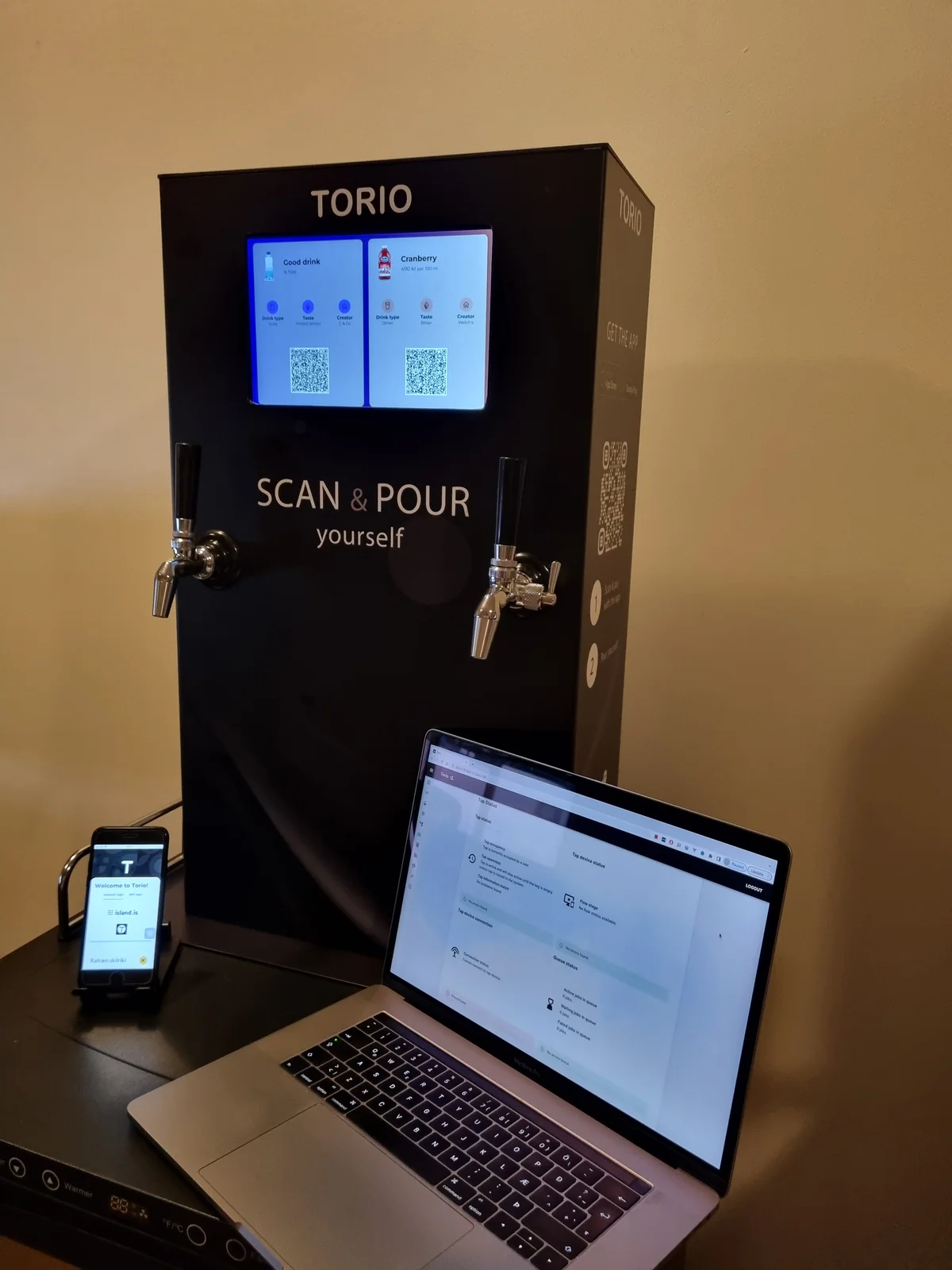 The PourSelf machine with its tablet, customer phone, and operator admin.